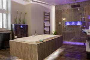 a large bathroom with a tub and a shower at Liberty at Utopia Penthouse by MGroupSA in Swansea