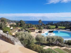 a resort with a swimming pool and the ocean at Superbe studio 4/5 pers dans résidence cap esterel in Agay - Saint Raphael
