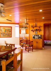 una cocina con techos de madera, mesas y sillas de madera en Vivir La Costa - La Mansión, en Santa Marta