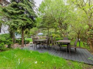 a wooden deck with tables and chairs in a garden at Pensjonat Przedwiośnie in Jurata