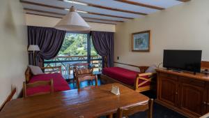 a living room with a television and a table with a table at Manzano Resort in Villa La Angostura