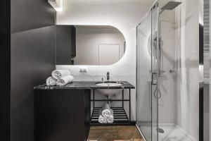 a bathroom with a sink and a shower at Apartament Moje Miasto in Gdynia