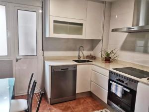a small kitchen with a sink and a stove at APTO. SANXURXO in Camariñas +11 photos