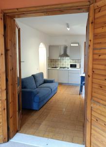 a living room with a blue couch and a kitchen at Sa di Mare in Bibione