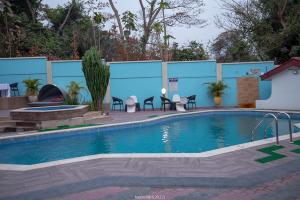 - une grande piscine avec des chaises à côté d'un bâtiment dans l'établissement ROYAL BASIN RESORT, à Kumasi