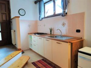 a kitchen with a sink and a clock on the wall at Le Betulle in Vezzano
