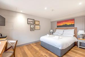 - une chambre avec un grand lit et un bureau dans l'établissement Charlcombe Inn, à Bath