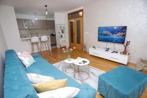a living room with a blue couch and a tv at Apartman Cezar Lukavica in Lukavica