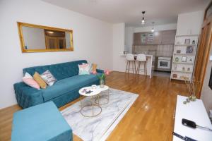 a living room with a blue couch and a table at Apartman Cezar Lukavica in Lukavica