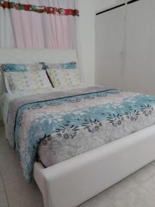 Una cama con una manta azul y blanca. en Casa ITCI Tours, en Cartagena de Indias