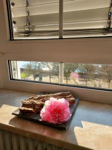 un trozo de pastel en un plato con una flor rosa en Fewo Siemens Mosel en Zell an der Mosel