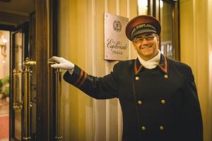 a man in a uniform is opening a door at Esplanade Prague in Prague