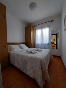 1 dormitorio con 1 cama con toallas en Apartamentos Xoroi en Cala'n Porter