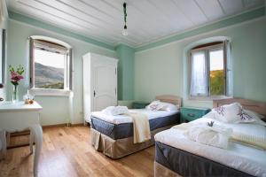 two beds in a room with two windows at Iconic Villas - Villa Rosa in Agia Effimia +32 photos