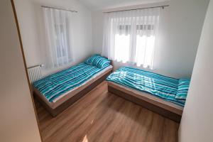 two beds in a small room with two windows at Golden Beach Apartments Siófok in Siófok