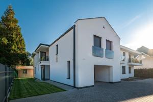 a large white house with a courtyard at Golden Beach Apartments Siófok by BLTN in Siófok