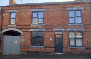 an old brick building with windows and a door at Springfield Gardens - Ilkeston - Close to M1-A52 Long Eaton - Nottingham - Derbyshire - 500Mbs WiFi! in Ilkeston