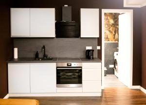 a kitchen with white cabinets and a stove at Arbio I Stylish Apart Schöneberg S-Bahn in Berlin