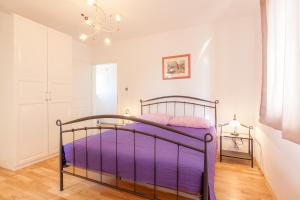 a bedroom with a metal bed with purple sheets at Villa Mare in Vrh