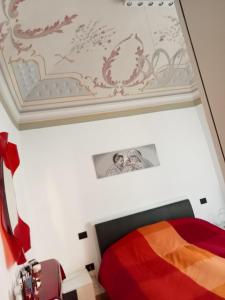 a bedroom with a colorful bed and a ceiling at La Casa dello Spolvero in LʼAquila