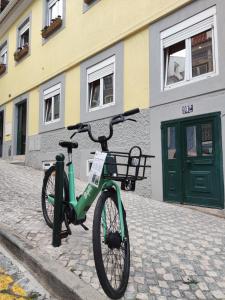a green bike parked in front of a building at Apartamento acolhedor no coração de Lisboa in Lisbon