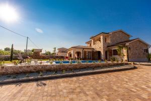 a large house with a brick driveway and a building at Villa Mare in Vrh