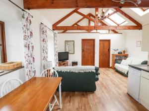 Una cocina y una sala de estar con un sofá y una mesa. en Brocks Barn, en Lanlivery