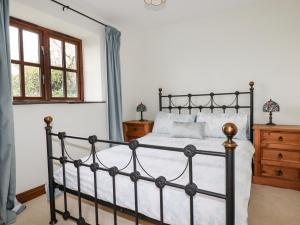 Un dormitorio con una cama negra y una ventana. en Brocks Barn, en Lanlivery