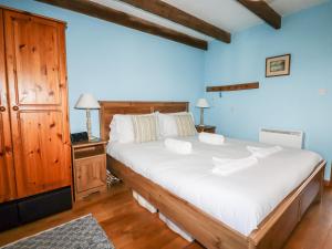 um quarto com uma grande cama branca com paredes azuis em 4 Mowhay Cottages em Saint Goran