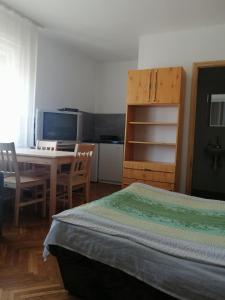 a bedroom with a bed and a table and a desk at Belv&aacute;rosi Vend&eacute;gh&aacute;z in Miskolc