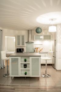 a kitchen with white cabinets and a table and chairs at Le Paisible T2-54m2-Proche Val d'Europe-Disney in Montévrain