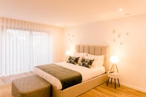 a bedroom with a large bed and a window at DCM LOFTS in Arcozelo