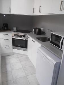 una cucina bianca con un lavello e un forno a microonde di Can Tianyico a Sa Pobla