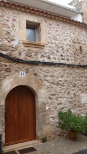 un edificio in pietra con una porta marrone e una finestra di Can Tianyico a Sa Pobla