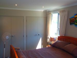 En eller flere senge i et værelse på Lakefront Fantail Cottage Lake Hawea, Wanaka