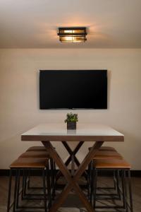 a table with chairs and a television on a wall at Sonesta Nashville Airport in Nashville