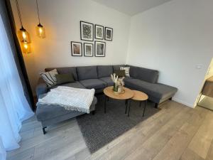 a living room with a couch and a table at Lee-Moderne Neubauwohnung in Strandnähe - Wallbox in Wremen