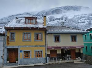 uma casa amarela com uma montanha ao fundo em Hotel Restaurante Casa Manolo em Páramo