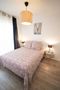 a bedroom with a bed and a table with a lamp at Le Délicieux T2-42m2-Disney in Montévrain