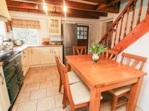een keuken met een houten tafel met stoelen en een tafel bij Eastburn Cottage in West Burton