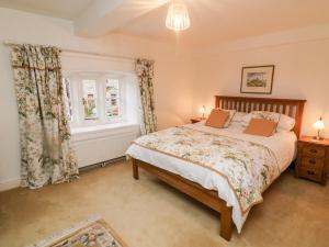 een slaapkamer met een bed en een raam bij Eastburn Cottage in West Burton