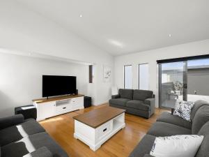 a living room with a couch and a tv at Anderson Central Torquay 36 in Torquay