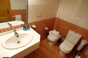 a bathroom with a sink and a toilet and a mirror at Hotel Restaurante Casa Manolo in Páramo +19 photos