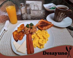 a plate of breakfast food on a table with a cup of coffee at Casa Colima in Isla de Tibás