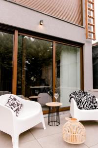 een patio met 2 witte stoelen en een tafel bij DCM LOFTS in Arcozelo