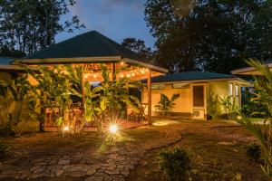 una casa iluminada por la noche con luces en Hotel Jinetes de Osa, en Drake