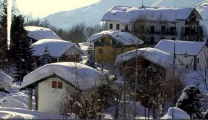 un pueblo cubierto de nieve con edificios y casas en white appartament, en Bagnolo Piemonte