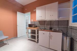 a kitchen with white cabinets and a microwave at Heart of Athens Thisio in Athens