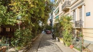 雅典的住宿－Heart of Athens Thisio，一条有植物和汽车的狭窄街道
