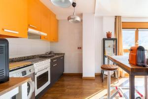 a kitchen with orange cabinets and a wooden table at Loft Felechosa in Felechosa